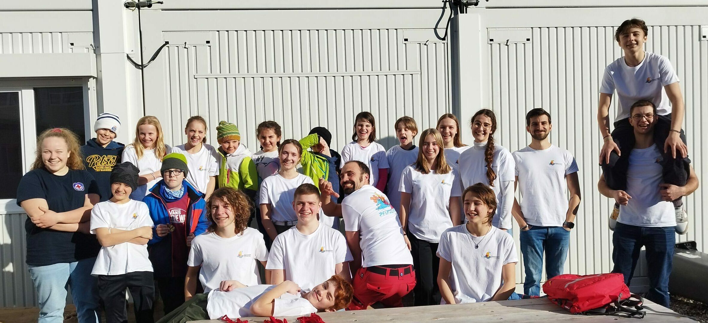 Die Teilnehmer der drei Stufen der Wasserwacht Schliersee posieren nach dem Wettbewerb mit ihren Betreuern für ein Gruppenfoto in der Sonne