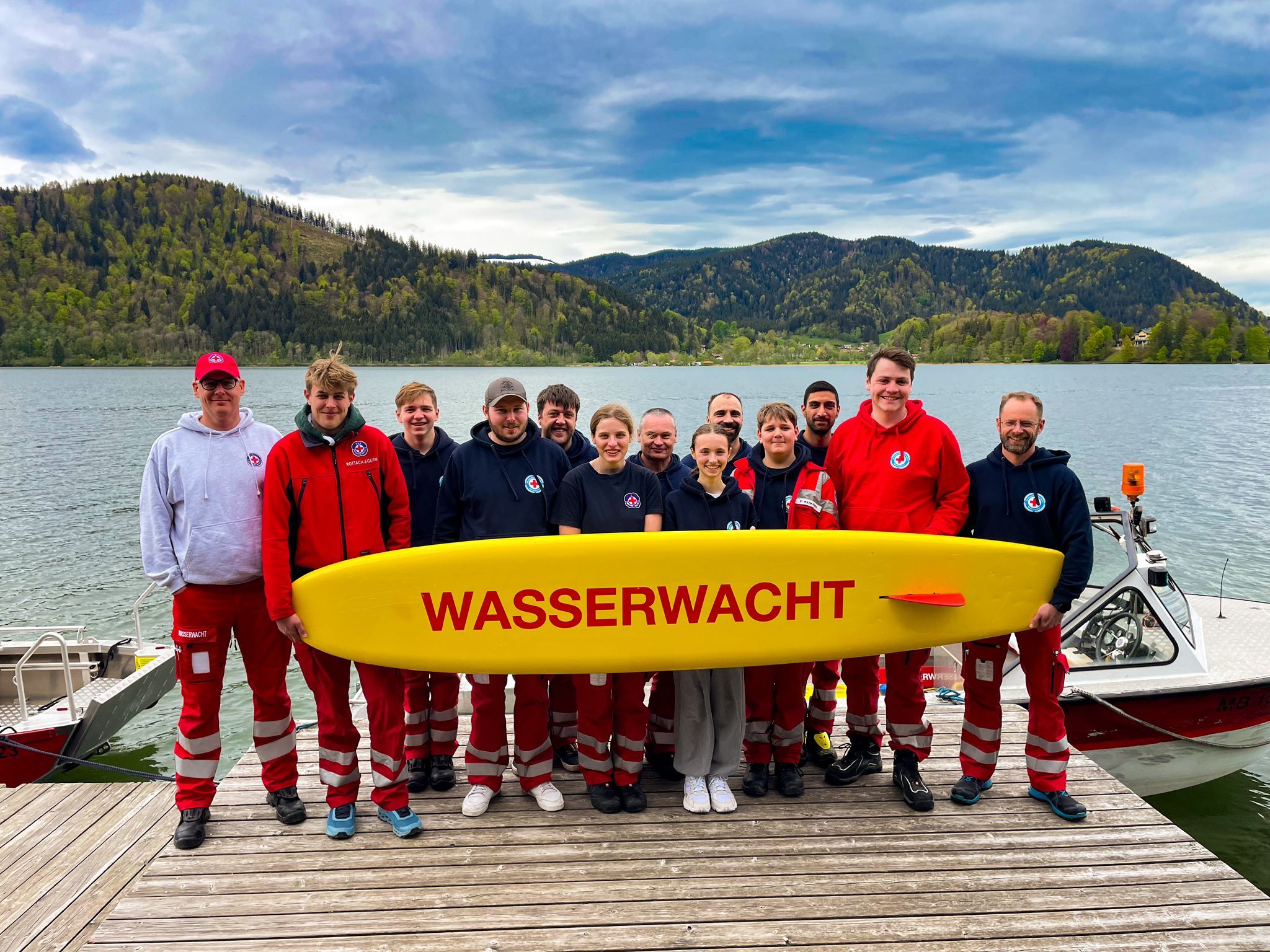 Auf dem Steg der Wachstation der Wasserwacht Schliersee posieren die Teilnehmer des Lehrganges nach erfolgreichem Abschluss mit Prüfern und Mimen
