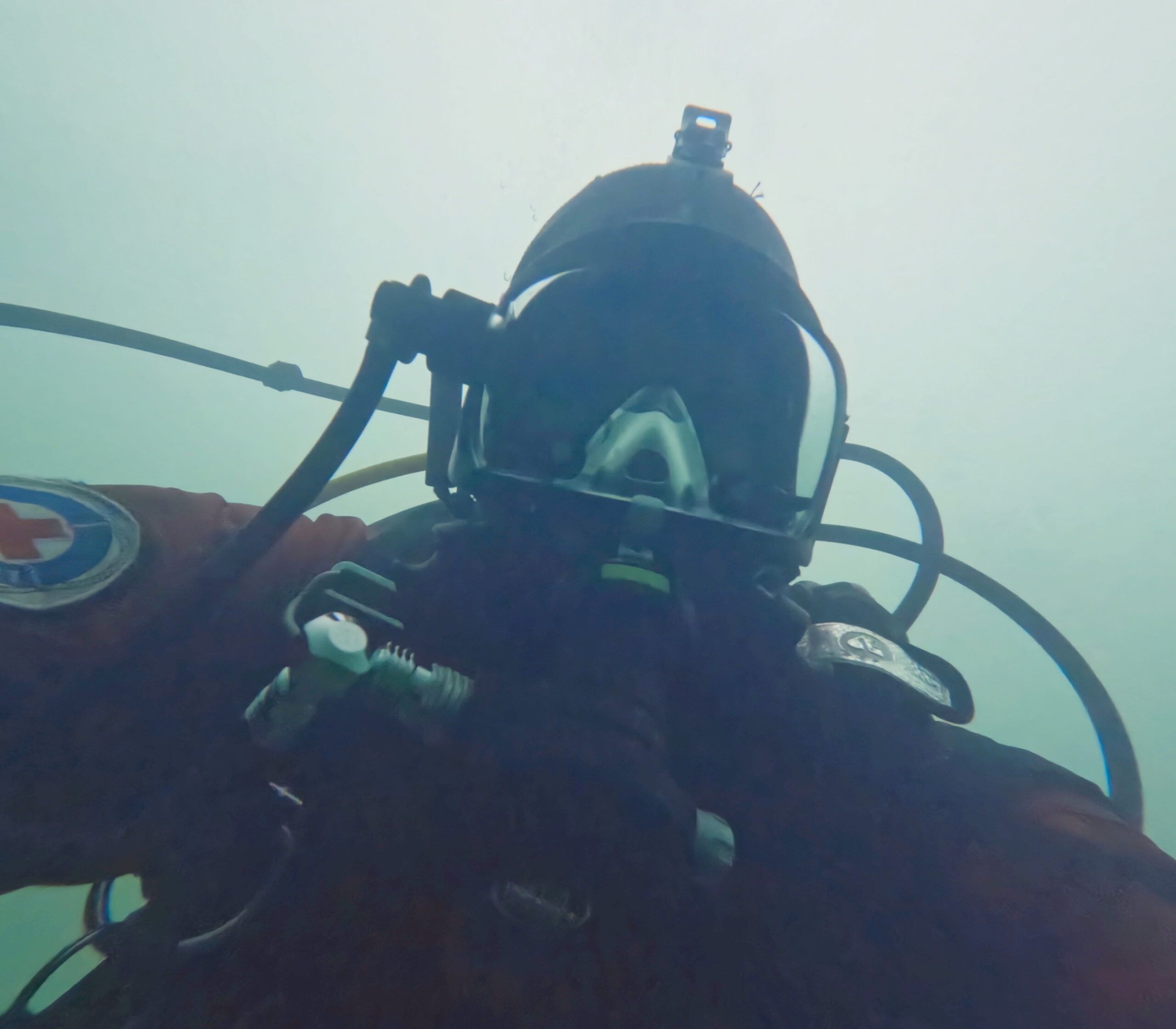 Taucher mit Anzug der Wasserwacht macht unter Wasser ein Selfie