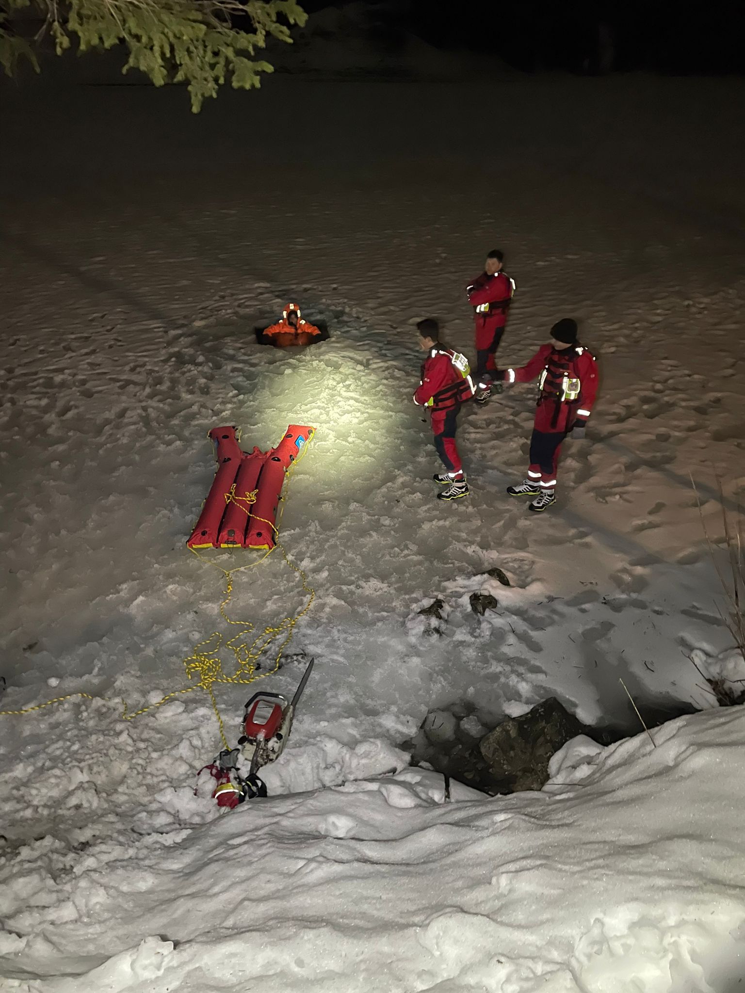 Eisrettungsschlitten auf dem gefrorenen Spitzingsee mit Rettungsschwimmern