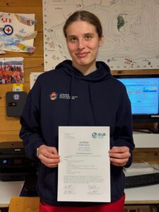Hanna Zlotek posiert mit dem Zertifikat zum erfolgreichen Abschluss des Gruppenleiterkurses des KLJB in der Wachstation